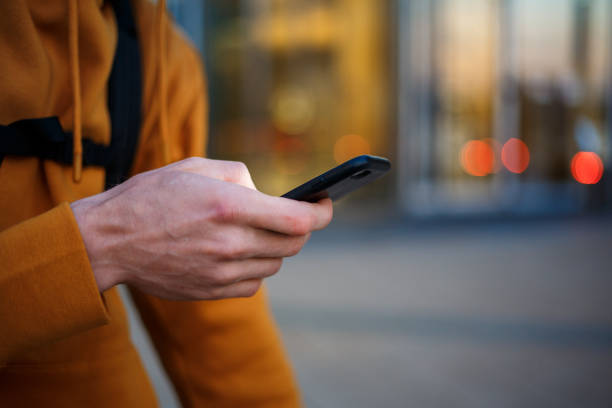 istock A man in a red jacket is holding a phone and typing on it 1279334976