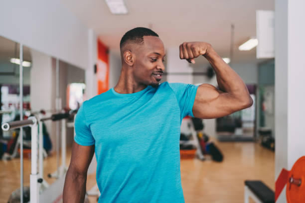 sportsman flexing biceps after workout - flexing muscles fotos imagens e fotografias de stock
