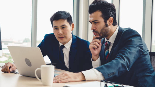 istock Two business people talk project strategy at office 1279338001