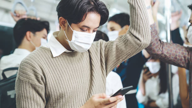 istock Traveler wearing face mask while using mobile phone on public train 1279338628