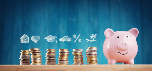 istock Piggy bank with stacked coins on blue background 1279341565
