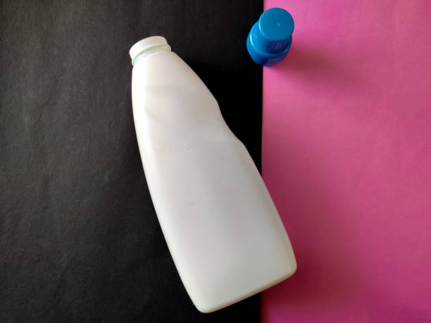 bottiglia di plastica bianca con cappuccio blu isolato su sfondo rosa e nero per detersivo o detergente o candeggina o ammorbidente in tessuto. - chemical bottle cap chores foto e immagini stock
