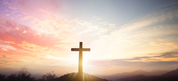 istock Christian cross concept: Silhouette cross on mountain sunset background 1279347541
