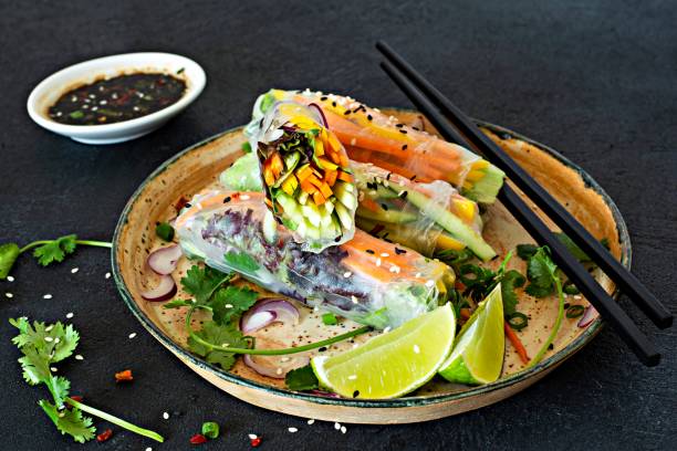 istock Fresh Asian appetizer Spring rolls (Nem) made from rice paper and raw vegetables and herbs with hot sauce on a dark background. Vietnamese Food 1279348624
