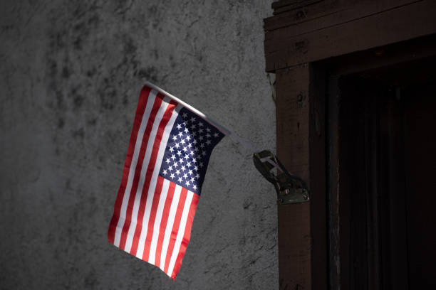 Upside-down flag as a sign of political protest Upside-down American Flag in front of a poor house as a sign of political distress, as tensions grow with the approaching presidential election upside down stock pictures, royalty-free photos & images
