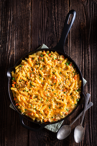 Pasta Chicken Casserole in a Cast Iron Skillet with Cheddar Cheese, Peas, Carrots and Cream