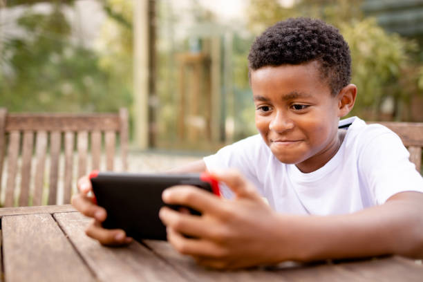 istock Cute boy using cell phone outdoors 1279354337