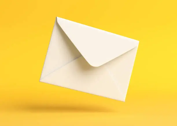 Photo of Envelope falling on the ground on a yellow backgorund