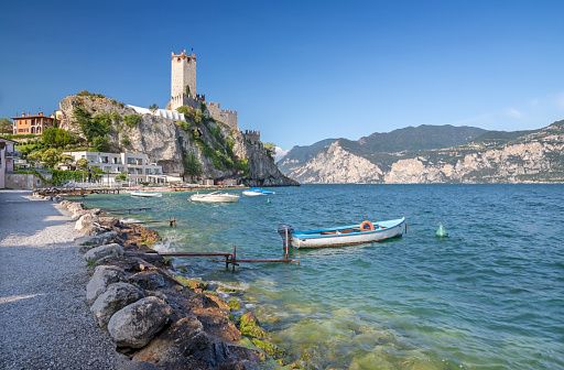 Malcesine - The beach of Lago di Garda lake with the town in the background.