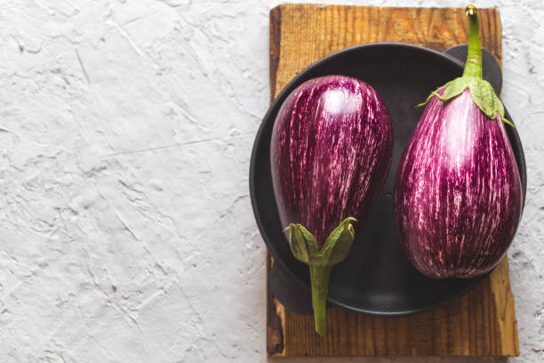 istock fresh ripe eggplants on a cutting board on a concrete gray background 1279360501