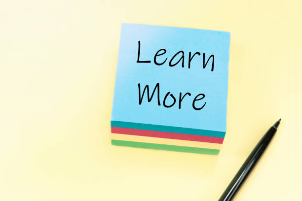 istock Text Learn More handwritten with black pen on a blue stiker. 1279361924