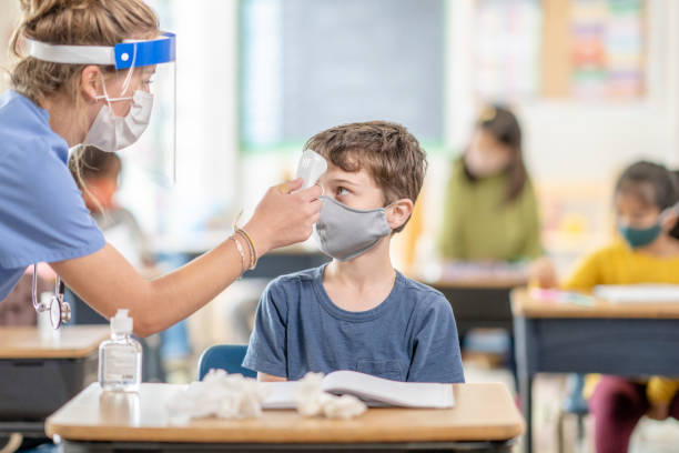 istock School nurse checking child for COVID-19 symptoms 1279364089