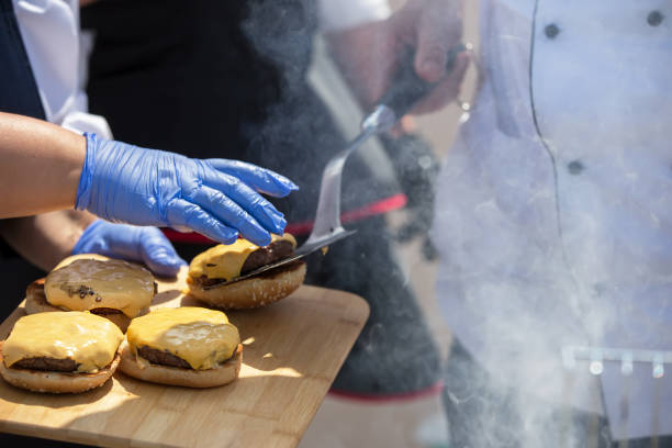 istock The hands of the cook make a hamburger. Fast food preparation process. 1279364464