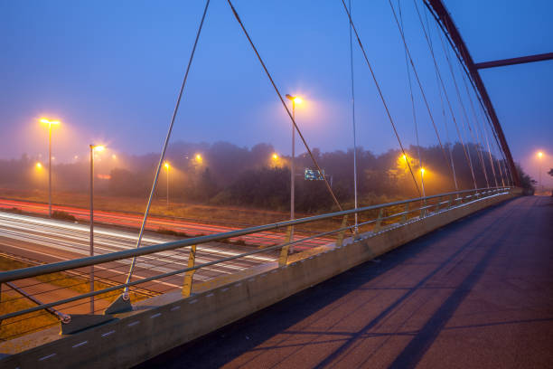 istock Bridge over freeway in the early morning with fog 1279365267
