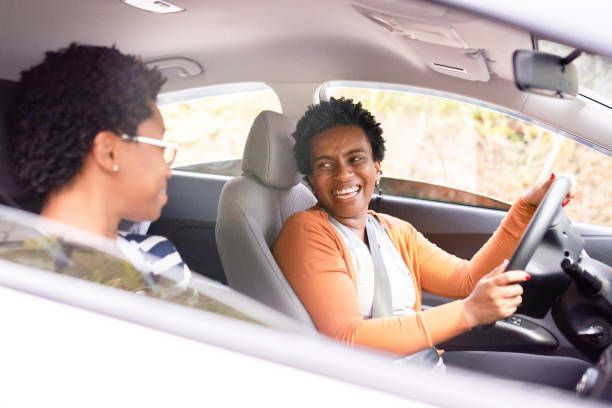 istock Two friends inside of a car, smiling and having fun while driving 1279365306