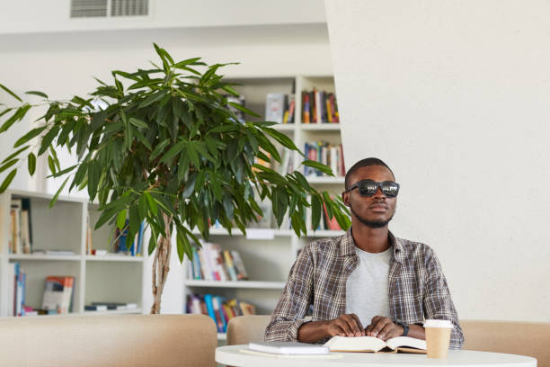 blind afrikansk man läser bok i biblioteket - tillgänglighet blind braille bildbanksfoton och bilder
