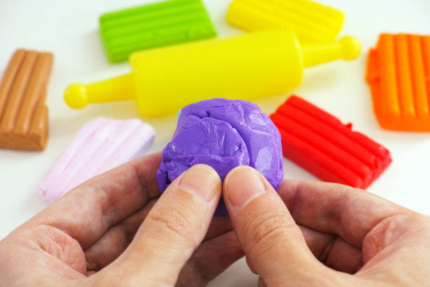 A man holding a piece of polymer clay in his hands A man holding a piece of polymer clay in his hands. Close up. polymer clay stock pictures, royalty-free photos & images