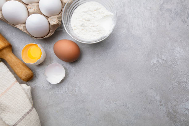 istock Baking cooking ingredients flour eggs rolling pin and kitchen textiles on gray concrete background. Cookie pie or cake recipe mockup 1279368732