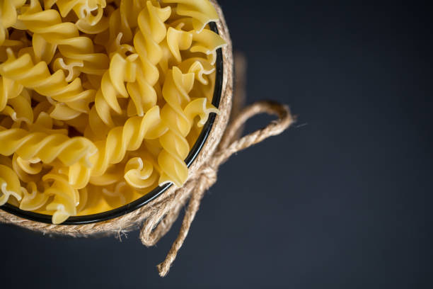 Raw fusilli pasta on a glass jar stock photo