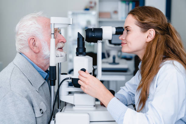 Smiling female ophthalmologist examining mature male patient with the help of ophthalmic equipment Smiling female ophthalmologist examining mature male patient with the help of ophthalmic equipment glaucoma photos stock pictures, royalty-free photos & images