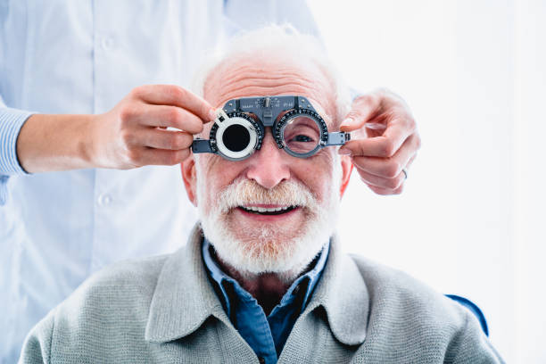 oculist putting ophthalmic glasses on smiling elderly male patient - patient happiness cheerful optometrist imagens e fotografias de stock