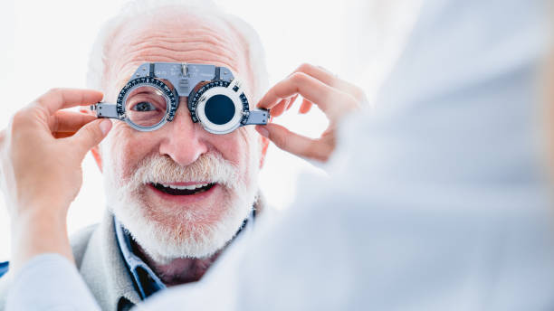 Smiling elderly man checking up vision with special ophthalmic glasses Smiling elderly man checking up vision with special ophthalmic glasses lens eye stock pictures, royalty-free photos & images