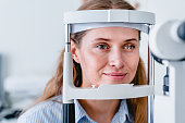 Close up photo of young smiling female patient during vision examination