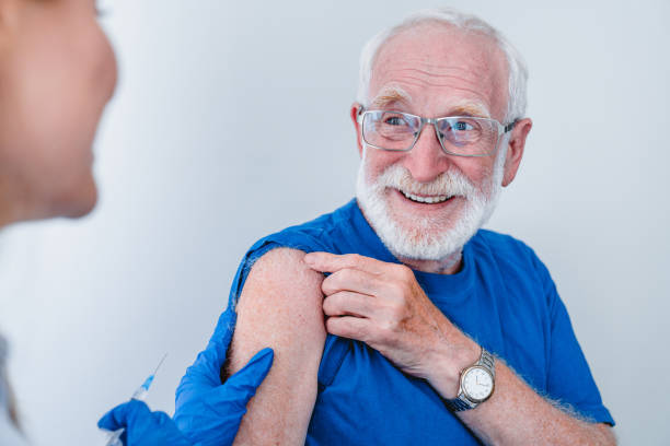 lächelnde ältere patient in brille ist immer bereit für injektionisoliert über weißem hintergrund - grippeimpfstoff stock-fotos und bilder