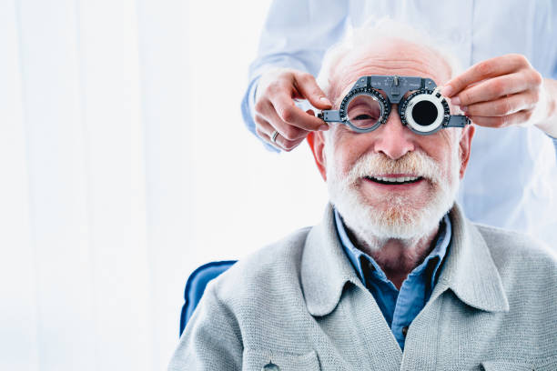 ritratto di un paziente maschio maturo felice sottoposto a controllo visivo con speciali occhiali oftalmici - optometrie foto e immagini stock