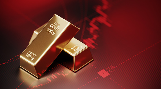 Gold bars sitting on red financial bar graph. Selective focus. Horizontal composition with copy space. Stock market and finance concept.