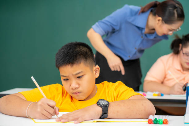 istock disability kid with autism boy in special classroom studying with Asian teacher 1279372533