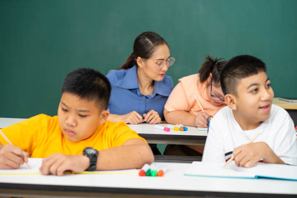 istock disability kid with autism boy in special classroom studying with Asian teacher 1279372534