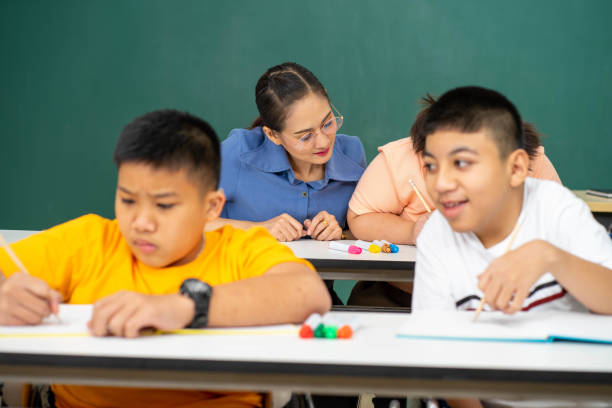 istock disability kid with autism boy in special classroom studying with Asian teacher 1279372535