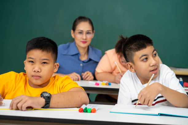 istock disability kid with autism boy in special classroom studying with Asian teacher 1279372549