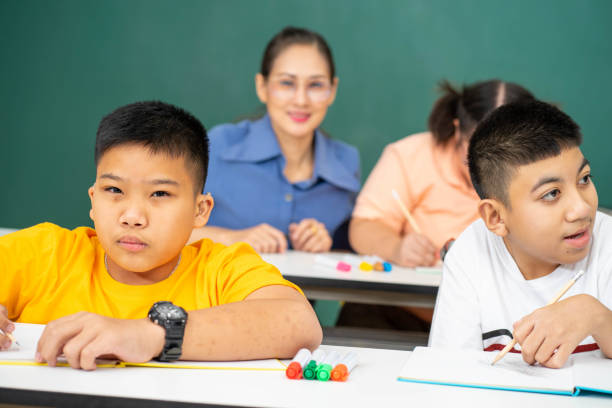 istock disability kid with autism boy in special classroom studying with Asian teacher 1279372551