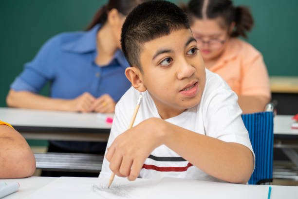 istock disability kid with autism boy in special classroom studying with Asian teacher 1279372553