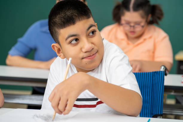 istock disability kid with autism boy in special classroom studying with Asian teacher 1279372576