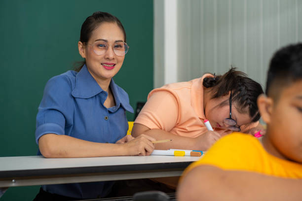 istock disability kid with autism boy in special classroom studying with Asian teacher 1279372588