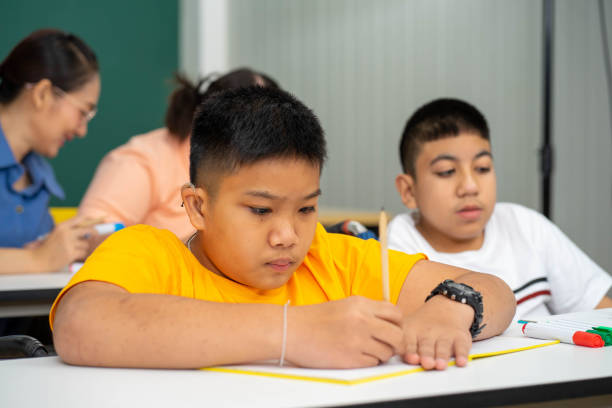 istock disability kid with autism boy in special classroom studying with Asian teacher 1279372592