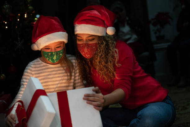 https://media.istockphoto.com/id/1279375772/photo/happy-mother-and-daughter-opening-christmas-gifts-together-wearing-facemasks.jpg?s=612x612&w=0&k=20&c=w4v5qYnYb2hyadlY_CS9V_cL98K1FC8O-PsQG7sjKW8=