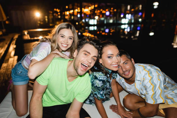 istock Excited young friends embracing and looking at camera at night 1279378319