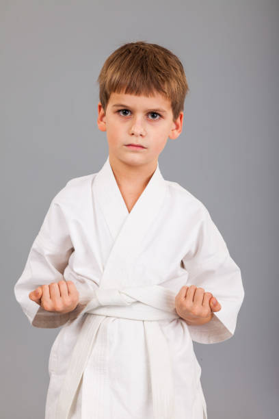 istock Karate boy in white kimono fighting 1279378354