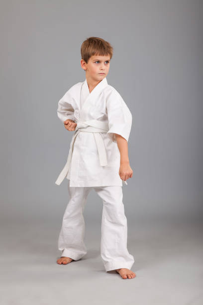 istock Karate boy in white kimono fighting 1279378490