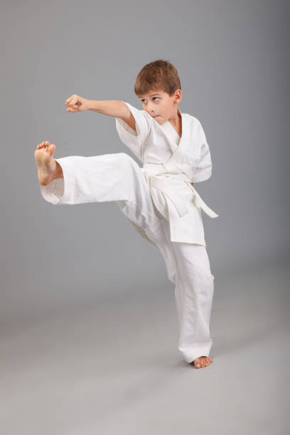 istock Karate boy in white kimono fighting 1279379619
