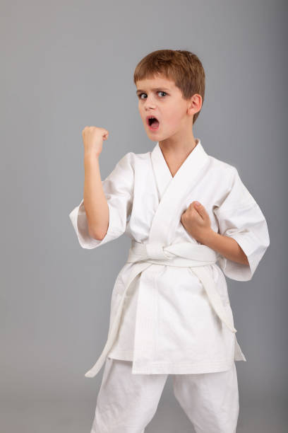 istock Karate boy in white kimono fighting 1279380022