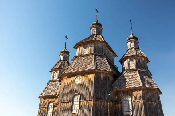 Wooden vintage church in Zaporozhian Sich medieval village, state of Cossacks on Khortytsia island, Ukraine. Sunny blue bright clear day