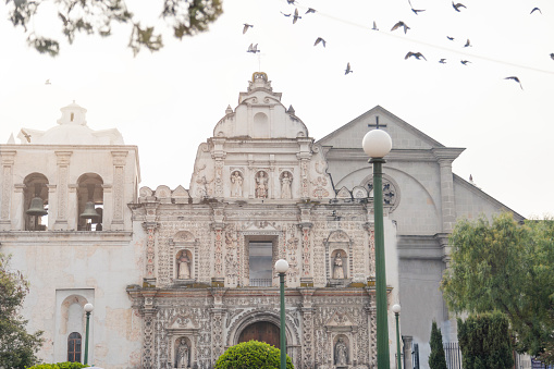 Palomas sobrevolando la Catedral del Espíritu Santo de Quetzaltenango Guatemala - Catedral neoclásica y barroca de la ciudad colonial - Iglesia católica temprano en la mañana photo