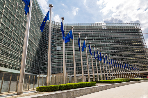 European flags in front of  headquarters of European commission in Brussels in summer day