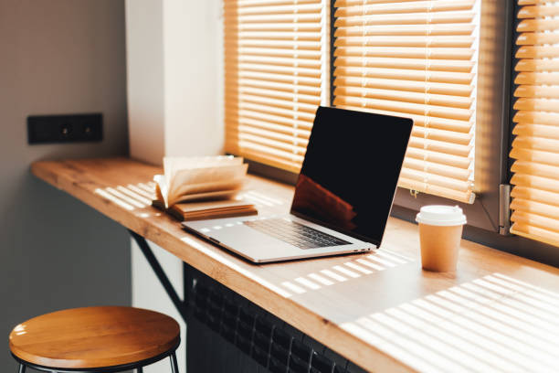 istock Computer laptop with coffee cup and open book on the modern wooden table 1279387338
