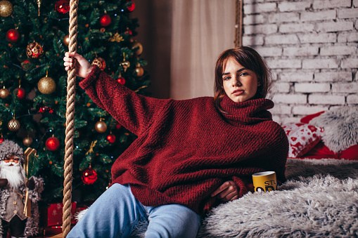 Hermosa chica en un suéter de gran tamaño caliente en un entorno de Navidad photo